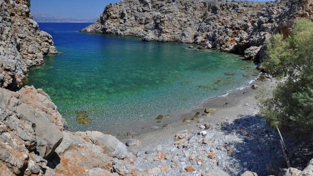A rocky coastal landscape with clear turquoise waters and a pebble beach. - Agrilos House - Amazing sea view - Sleeps 4 (Mirsini)