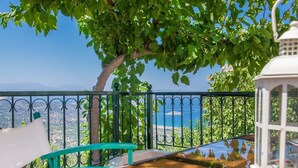 A balcony with a view of the sea, a tree, and a white lantern. - Agrilos House - Amazing sea view - Sleeps 4 (Mirsini)