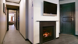 Un pasillo con chimenea y televisión montada en la pared.