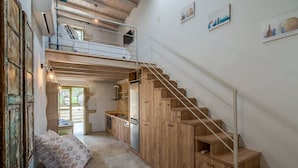 A loft-style bedroom with a bunk bed, a staircase leading to a kitchen, and a view of the outdoors. - Traditional Villa w/Heated Pool, 5km to the Beach (Καστελλος)