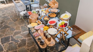 A buffet setup with various food items and a pool in the background. - Sunshine Boutique Hotel (Hersonissos)