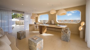 A modern interior with a large window, a kitchen area, and a seating area. - Sunshine Boutique Hotel (Hersonissos)