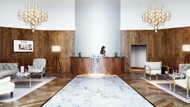 Eine moderne Lobby mit einer zentralen Rezeption, zwei Kronleuchtern und einem Marmorboden.