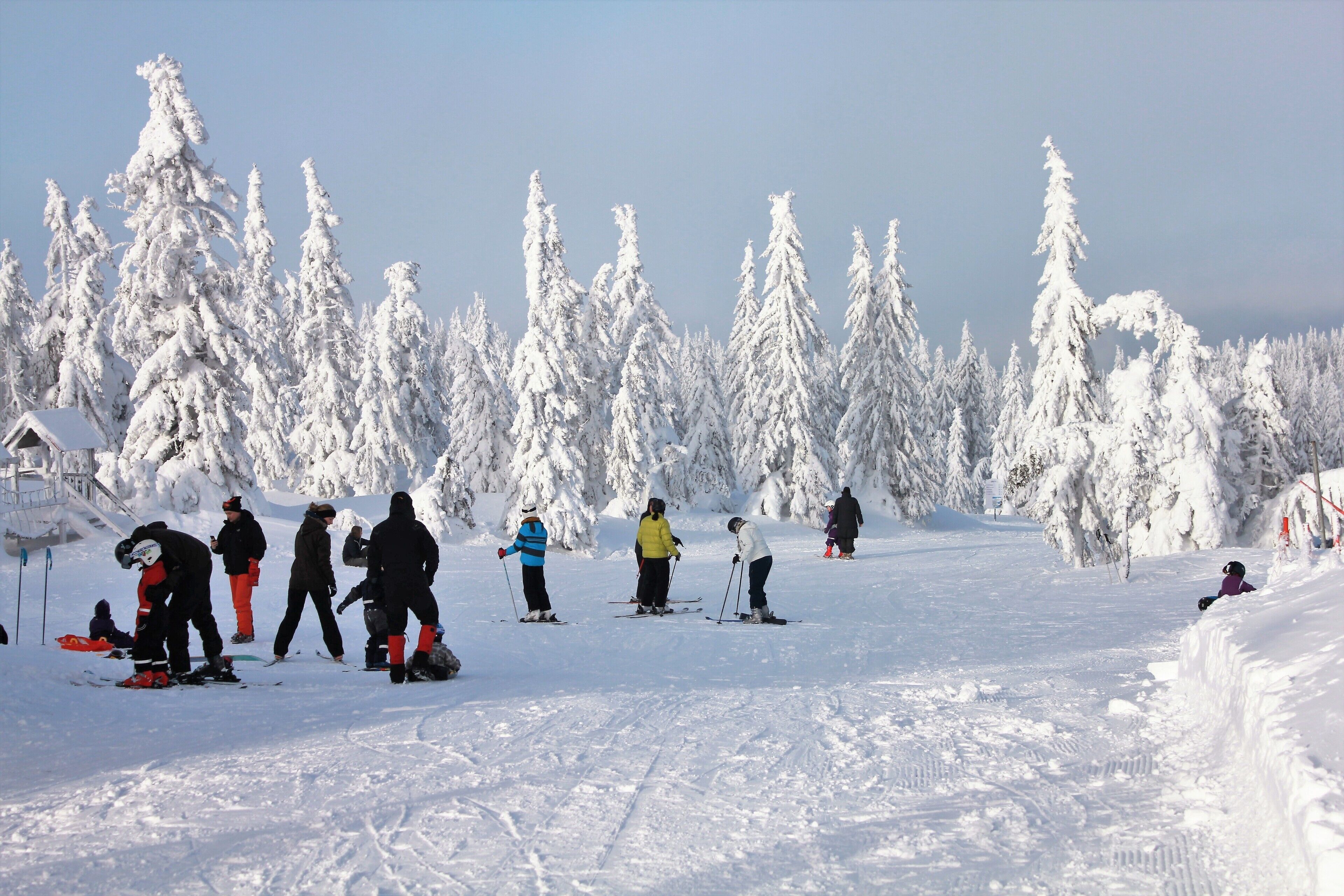 A snowy ski slope with skiers and snowboarders.