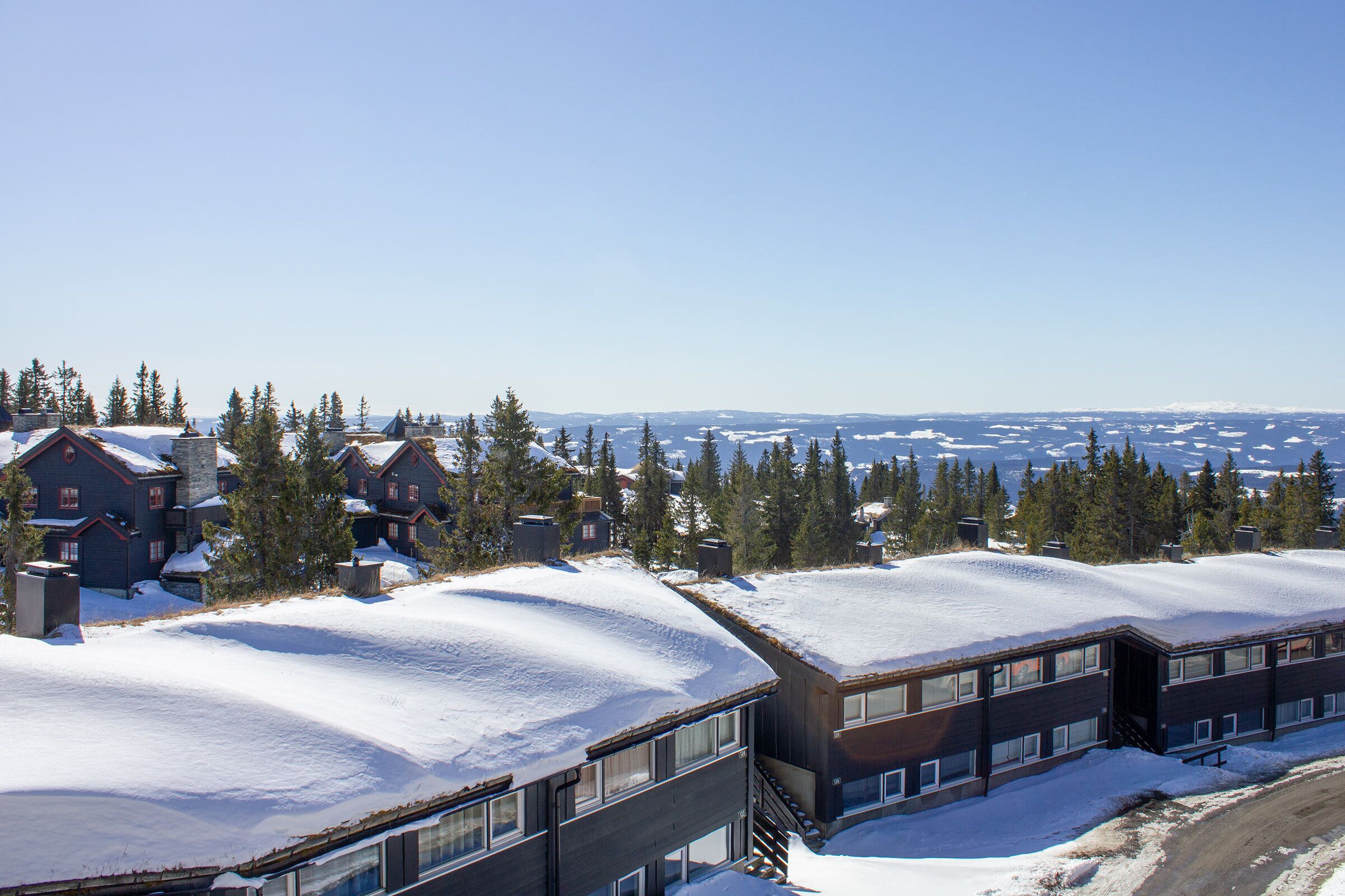 A snow-covered building with multiple windows and a clear view of the surrounding landscape.