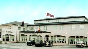 Ein Hotel mit einem Schild, auf dem 'HOTEL' steht, und ein Gebäude mit der Bezeichnung 'ONDA AUTOSERVICIO'.