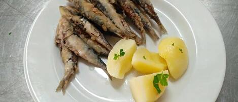 A plate with grilled fish and boiled potatoes.