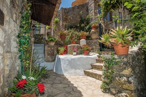 Relax in a charming courtyard surrounded by lush greenery and a stone-paved space perfect for socializing.