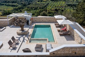 A rooftop pool area with lounge chairs, a small table, and umbrellas. - La Serena Residence & Farm with Heated Pool (Ρέθυμνο)
