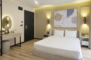 Une chambre moderne avec un grand lit, des tables de chevet, un bureau et un miroir.