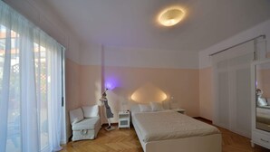 A bedroom with a large bed, a bedside table, a chair, and a lamp. - Jasmine in the heart of Kolonaki. (Αθήνα)