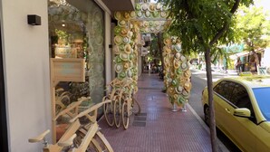 A storefront with a bicycle rack outside and a yellow taxi parked nearby. - Jasmine in the heart of Kolonaki. (Αθήνα)