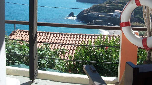 Un balcón con vista al mar y a las montañas.