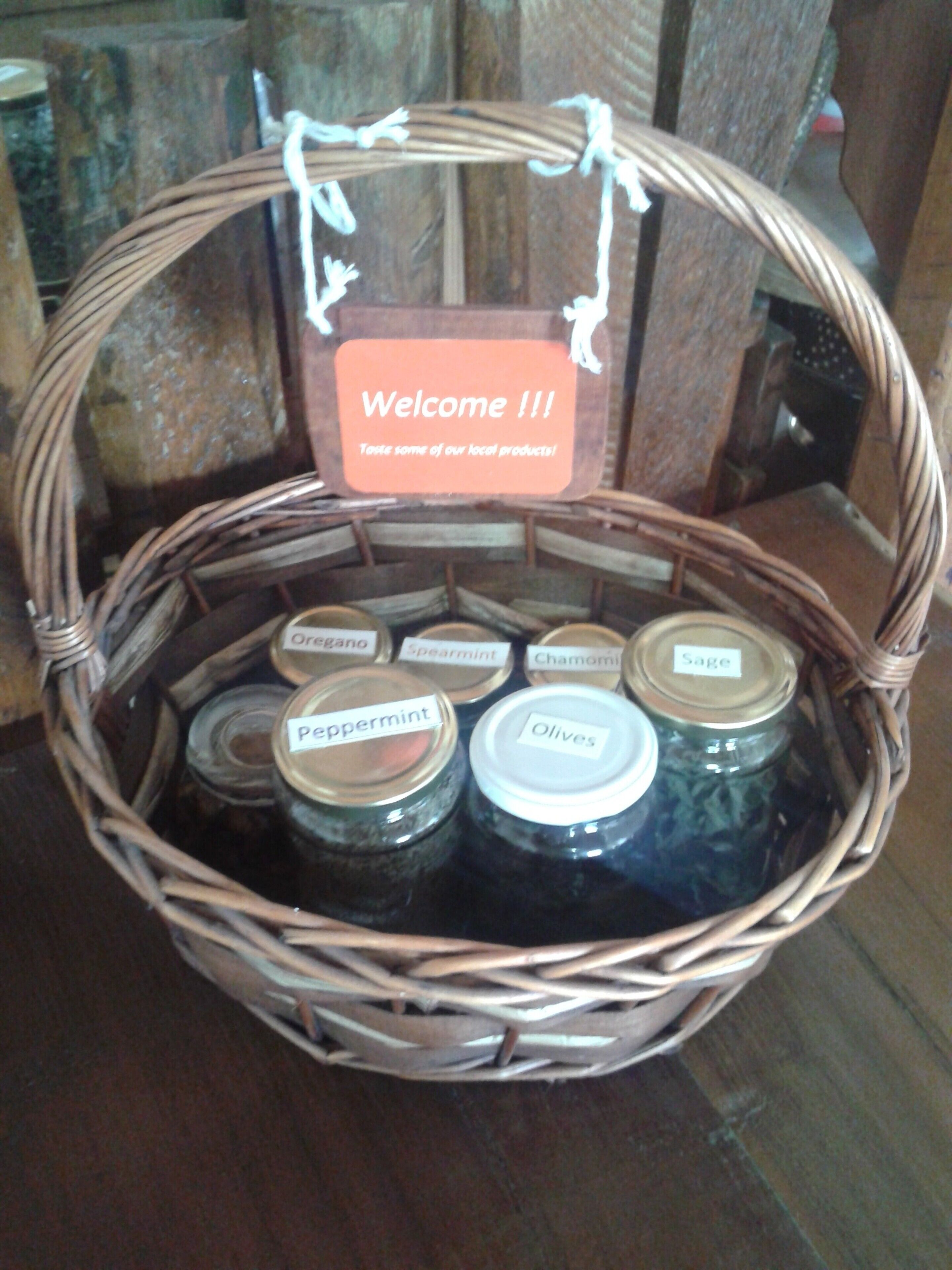 A wicker basket with jars labeled with various herbs and spices, and a welcome sign.
