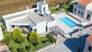 A modern house with a swimming pool, a covered patio, and a well-maintained lawn. - Eleanna villas. Villa Athena (Καβρός)