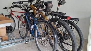 Bicicletas estacionadas en el interior, con piso de baldosas y paredes blancas.