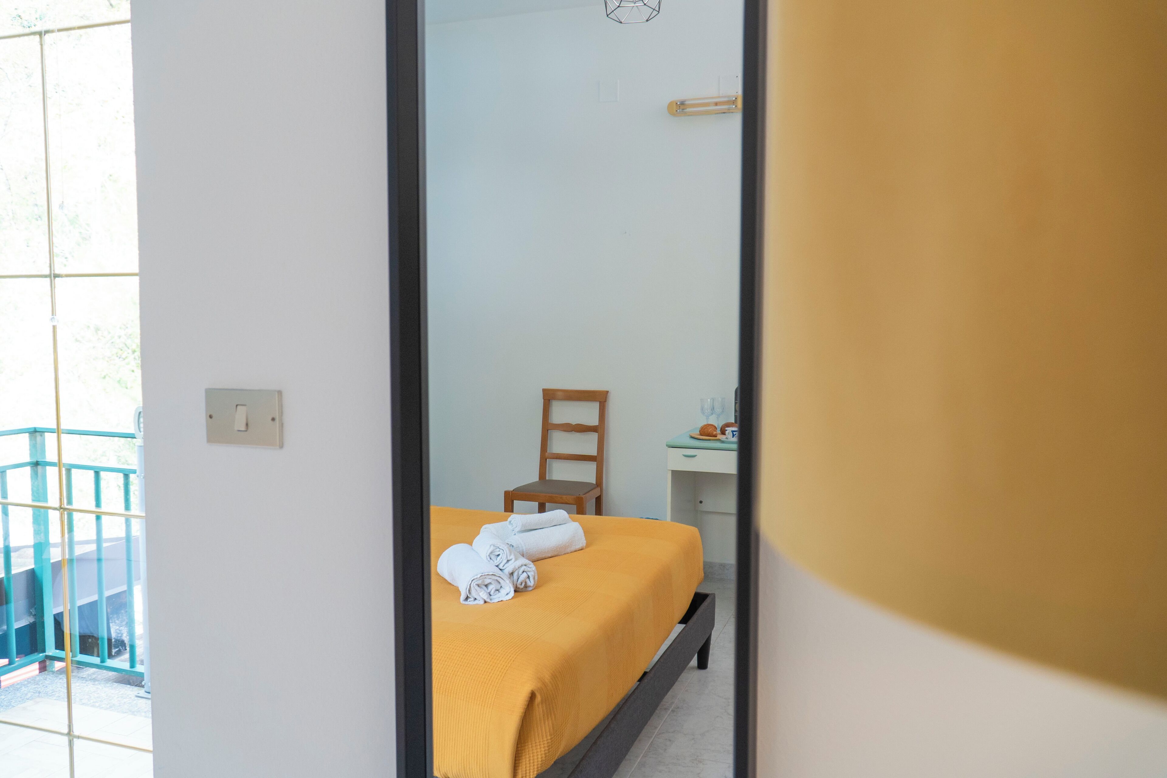 Una habitación de hotel con una cama, una silla, un escritorio y una ventana.