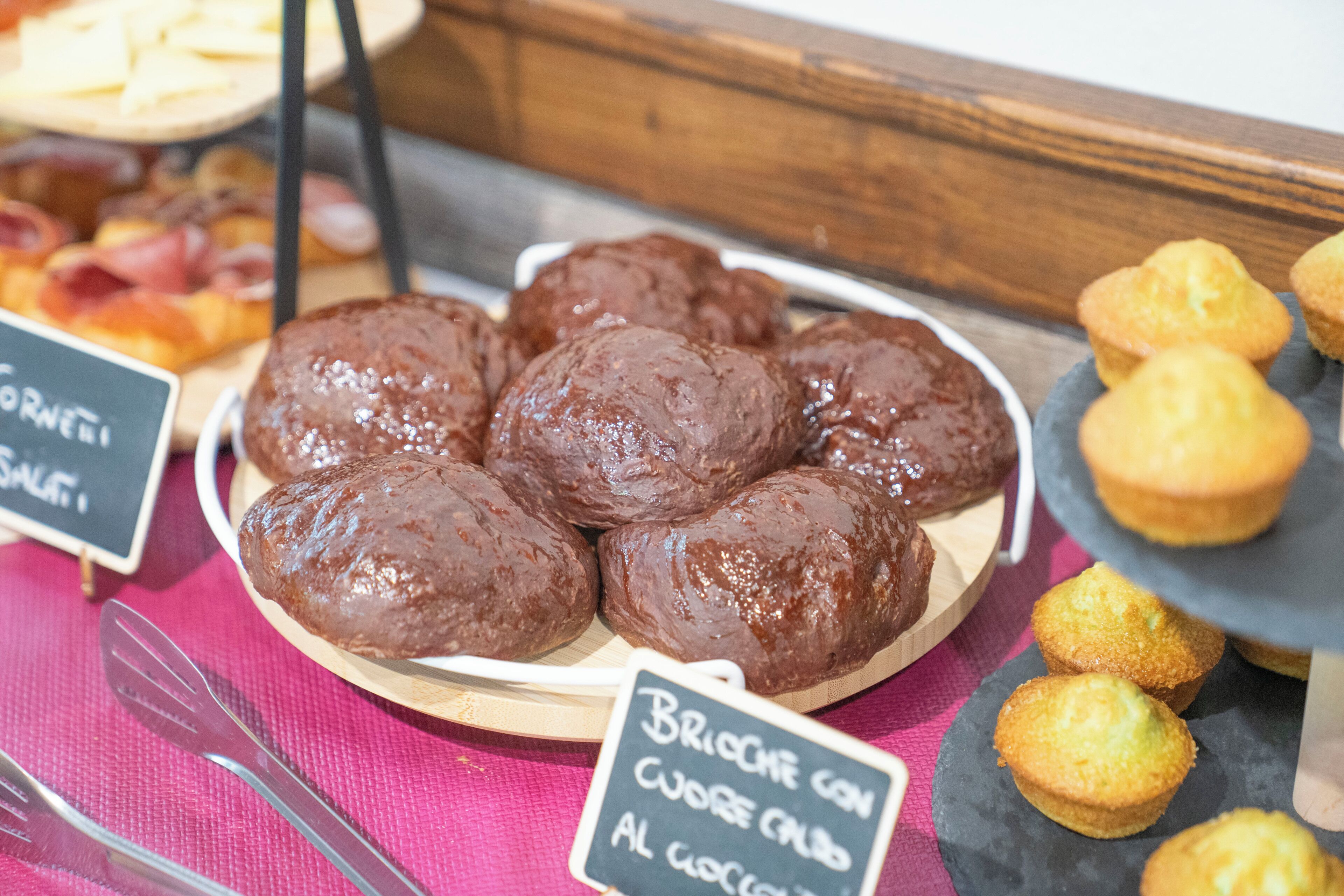 Eine Auswahl an Speisen, darunter schokoladenüberzogene Gebäckstücke und Muffins.