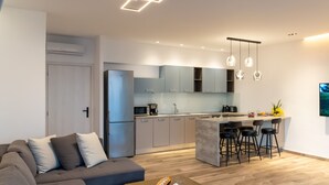 A modern kitchen with grey cabinets, a central island with bar stools, and pendant lighting. - Mary 1 Waterfront villa,Private pool,South Crete (Frangocastello)