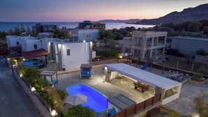 Quartiere residenziale con piscina, area salotto esterna e vista sul mare.