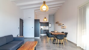 Ein modernes Wohnzimmer mit einer Couch, einem Holztisch und einem Essbereich mit Tisch und Stühlen.