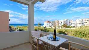 A balcony with a table, chairs, and a bottle of wine. - Vasiliki Villa with Private Pool (Ιαλυσός)