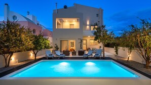 A modern two-story house with a swimming pool, lounge chairs, and a well-lit outdoor area. - Vasiliki Villa with Private Pool (Ιαλυσός)
