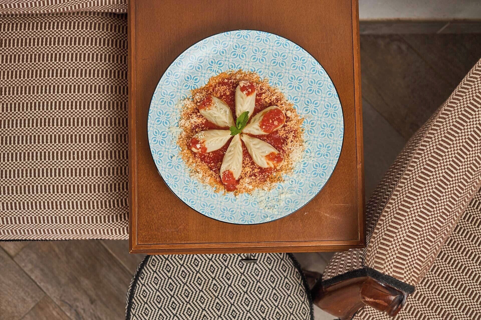 A round plate with food on a wooden table.