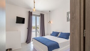A modern bedroom with a large bed, a television, and a balcony with curtains. - BLUEBELL VILLA SUNRISE (ΚΑΜΠΟΣ)