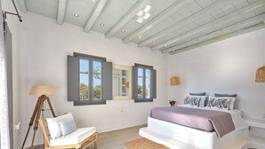 A bedroom with a bed, bedside table, lamp, chair, and a window with shutters. - 𝐒𝐞𝐚𝐒𝐚𝐥𝐭 𝐃𝐫𝐞𝐚𝐦 𝐕𝐢𝐥𝐥𝐚, 𝐒𝐚𝐧𝐭𝐚 𝐌𝐚𝐫𝐢𝐚 𝟓 𝐦𝐢𝐧 𝐟𝐫𝐨𝐦 𝐍𝐚𝐨𝐮𝐬𝐚 (Νάουσα)