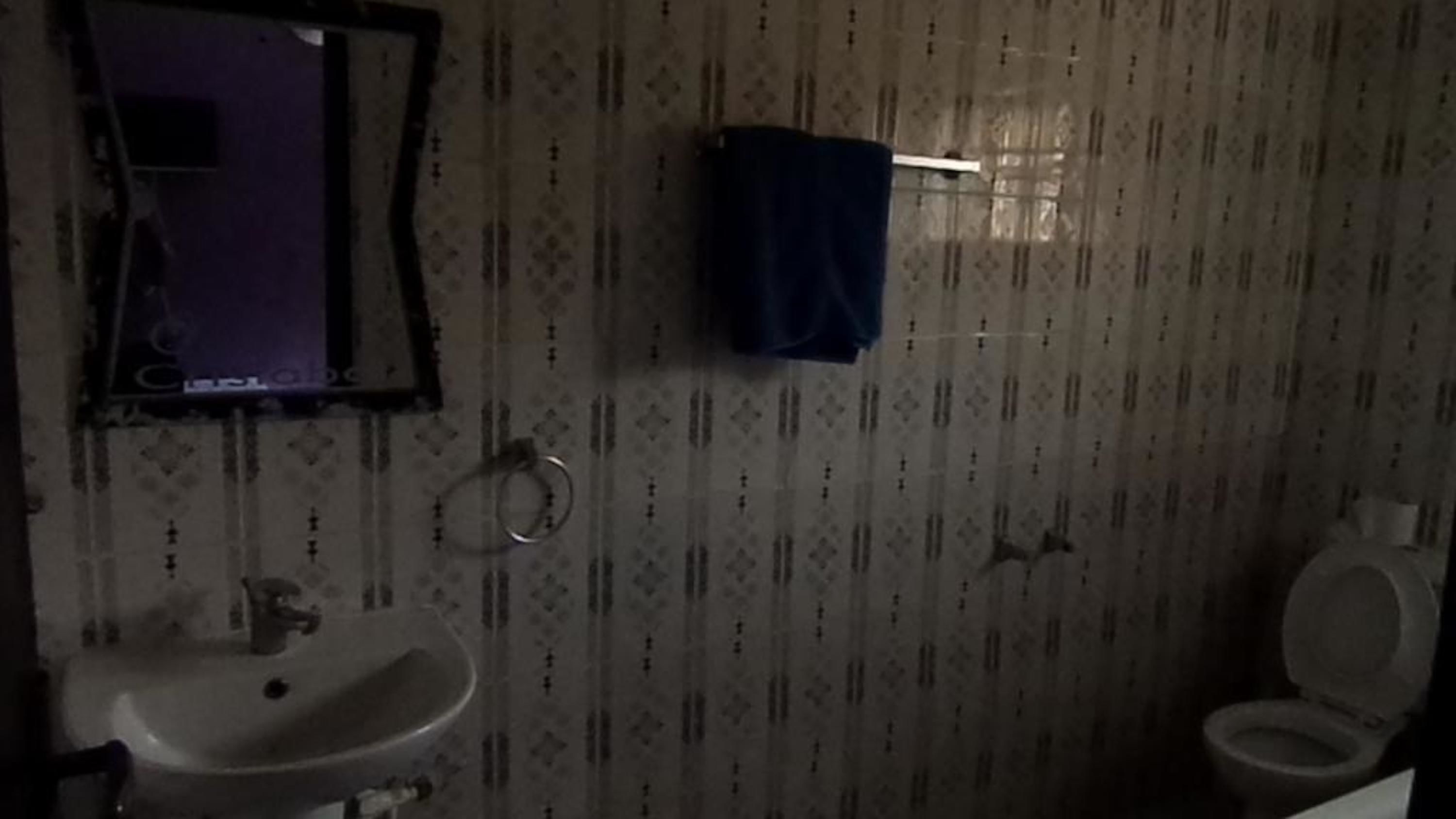 A bathroom with a sink, toilet, and mirror.