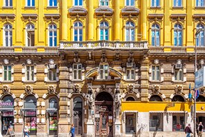 A historic building with ornate architectural details, including columns and decorative moldings. - Deluxe Ploech (Rijeka)