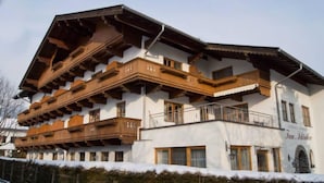 Un edificio de varios pisos con balcones de madera y un cartel que dice "FAM. Schindler".
