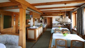 A wooden interior with a dining area, kitchen, and seating. - Pension Birgit (Todtnau)