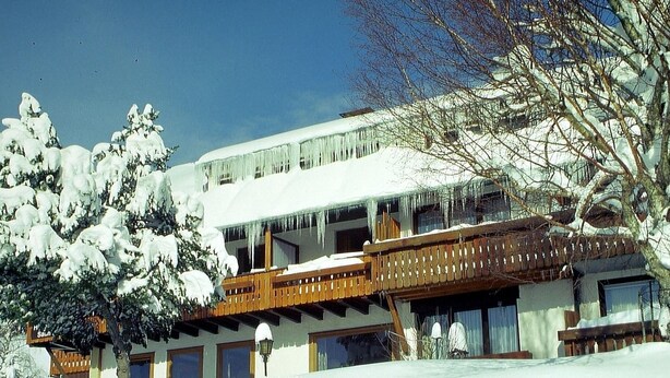 A snow-covered building with a wooden balcony and multiple windows. - Pension Birgit (Todtnau)