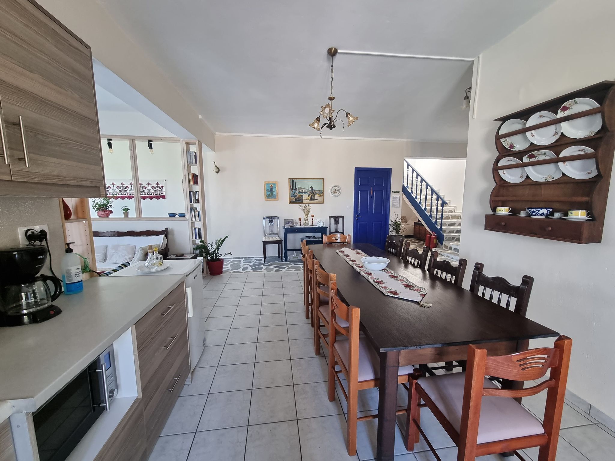 Une cuisine moderne avec un coin repas, comprenant une table en bois, des chaises et un escalier menant à un autre niveau.