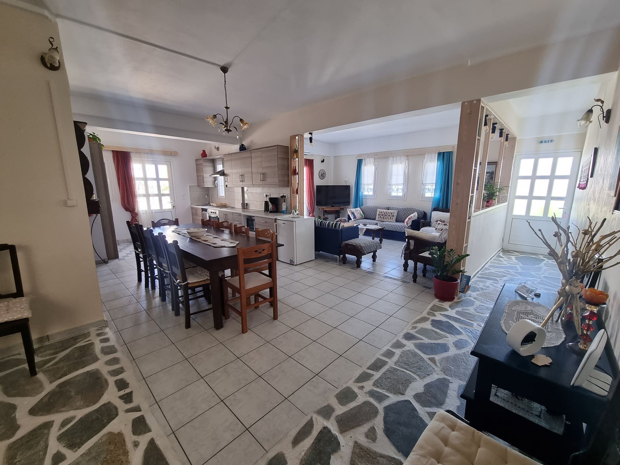Amplia sala de estar con mesa de comedor, sofás y una cocina al fondo.
