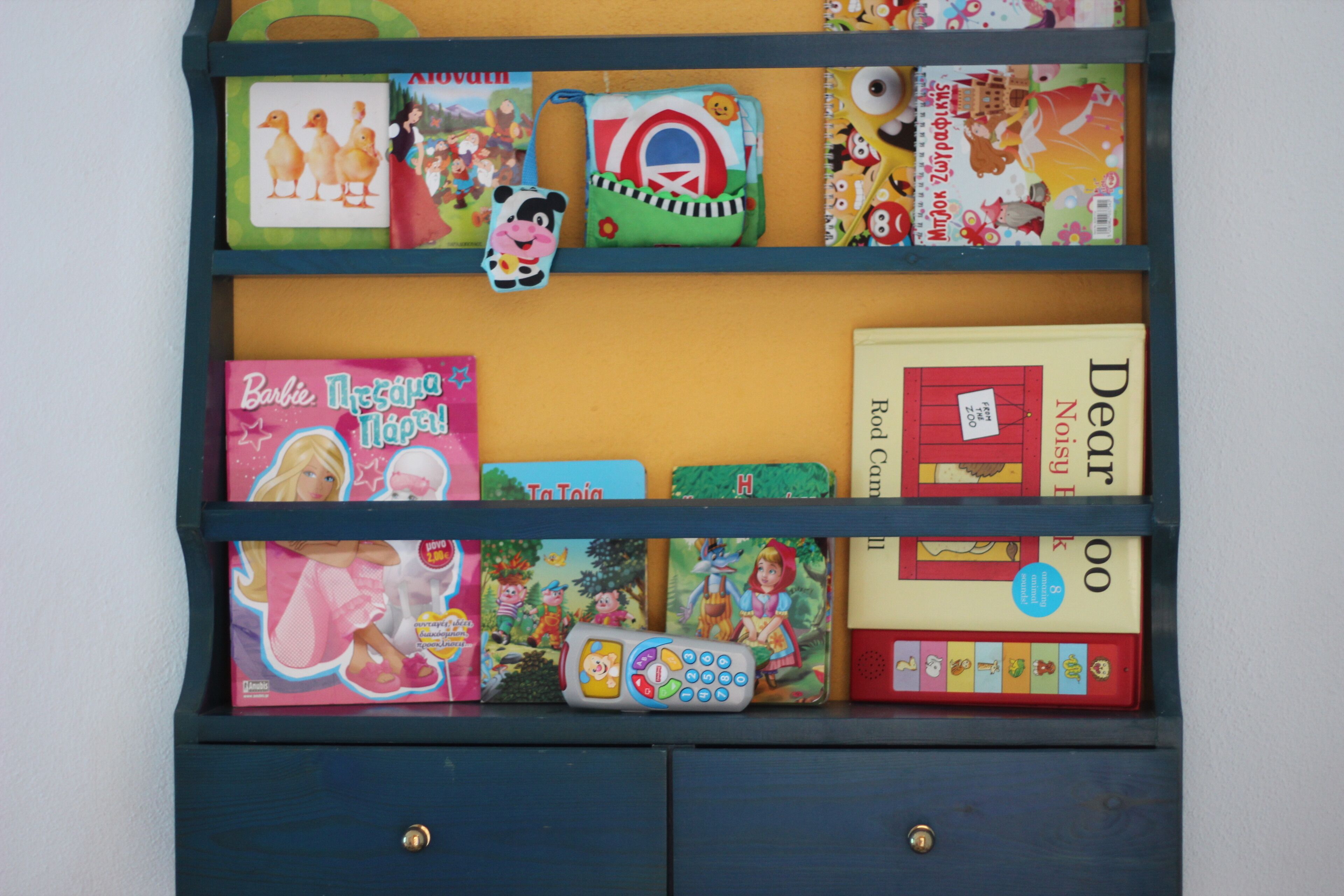 Una estanteria amb llibres i joguines infantils.
