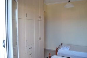 Un dormitorio con una cama, un armario y una ventana.