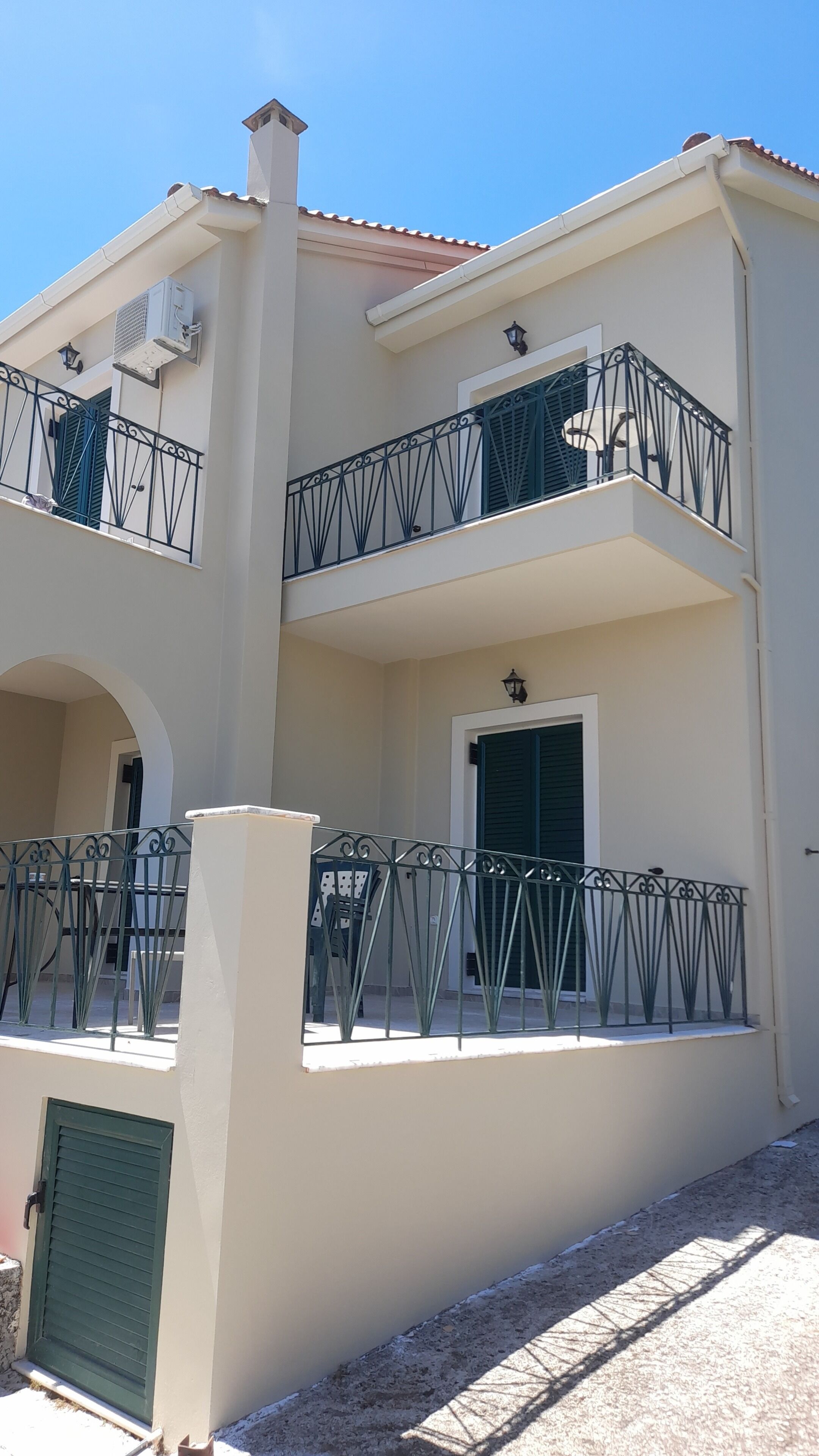 A multi-story building with balconies, a door, and a window.