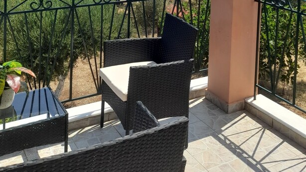 A balcony with wicker furniture, a view of a lake, and distant mountains. - VILLA ANDREAS Family- friendly & friends- friendly (Καραβόμυλος)