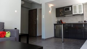 Cozinha moderna com armários escuros e micro-ondas embutido.