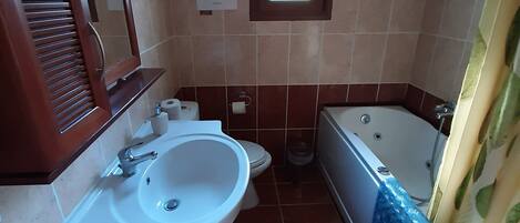 A bathroom with a sink, toilet, and bathtub.