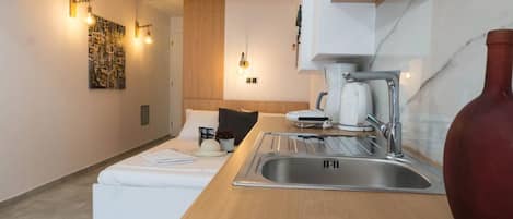 A compact kitchenette with a sink, a coffee maker, and a small countertop.