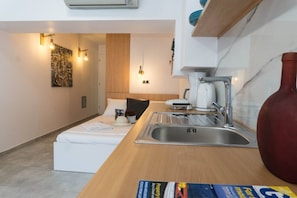 A compact kitchenette with a sink, a coffee maker, and a small countertop.