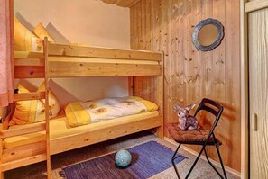 A bunk bed room with a wooden floor, a small chair, and a round mirror on the wall. - Bayerwald Ferienhof (Eppenschlag)
