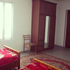 Habitación triple, balcón | Escritorio, cortinas blackout, tabla de planchar con plancha y cunas