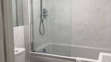 Un bagno moderno con doccia vetrata, un water bianco e un lavandino.