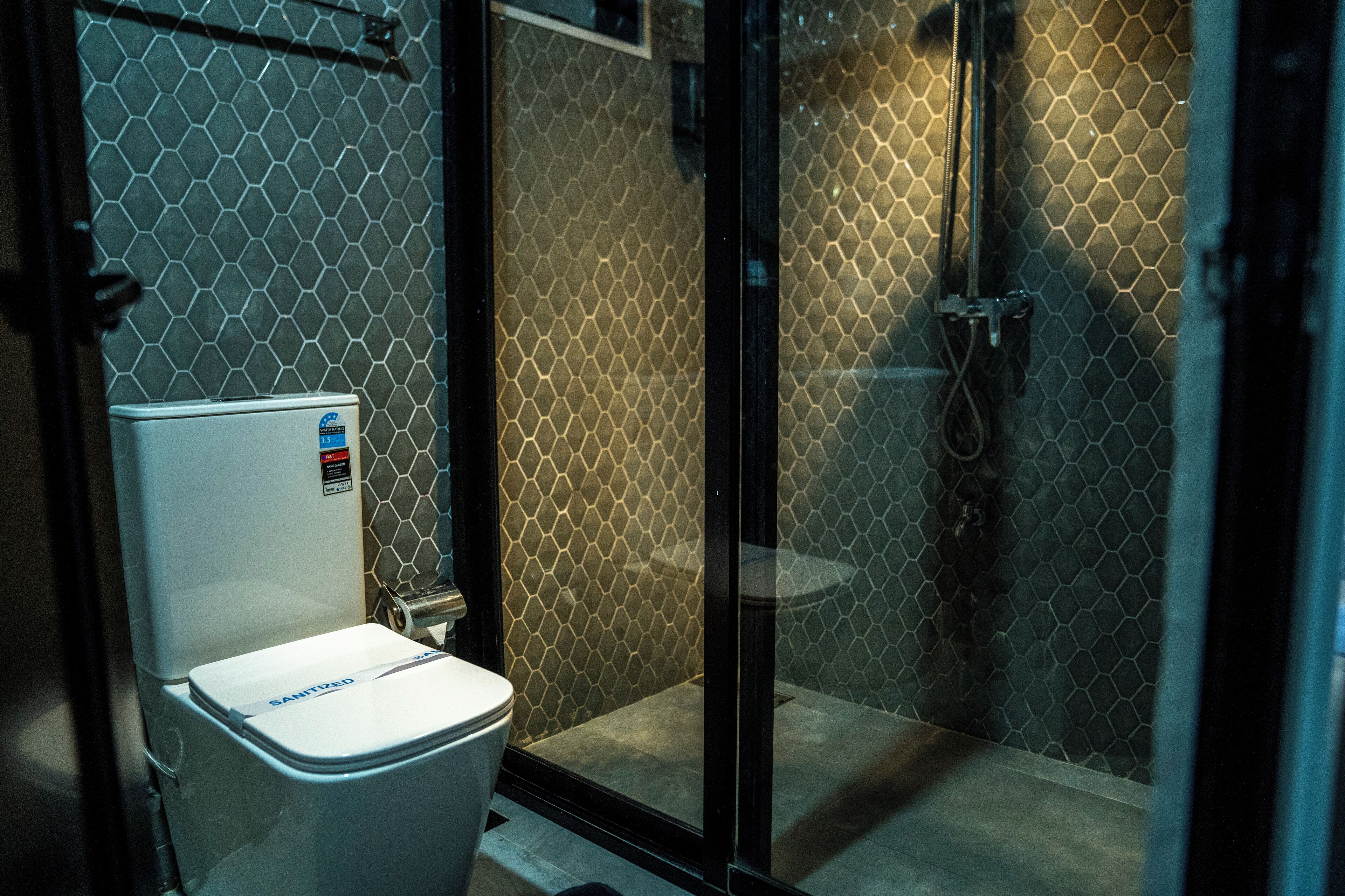 A bathroom with a toilet, a shower area, and a glass door.