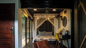 A bedroom with a canopy bed, a desk with a chair, and a view of the outdoors. - Area 4 eco cubes (Ella)